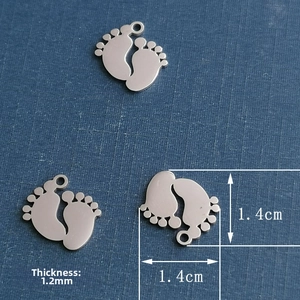Macro view of baby feet stainless steel pendant charm with dimensions 1.4cm and thickness