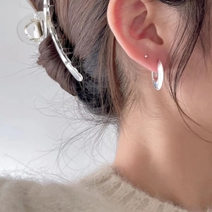 Minimalist silver geometric layered earrings shown on a model for a modern look