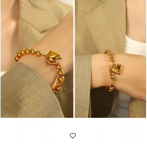 Detailed view of the 18K gold beaded bracelet featuring a bold and vintage heart pendant
