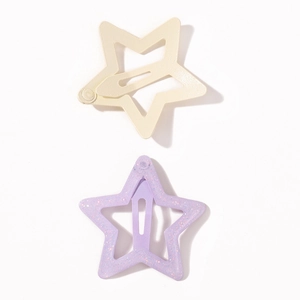 Detail view of star-shaped snap hair clips in matte yellow and glittery purple finish
