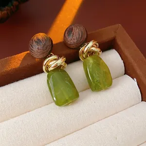 Vintage geometric earrings with brown wood, gold metal knot, and green resin pendant