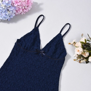 Detailed macro view of dark blue lace nightdress featuring a delicate bow and floral texture