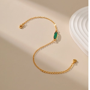 Dettaglio catena placcata oro 18K con gemma ovale verde e chiusura a moschettone