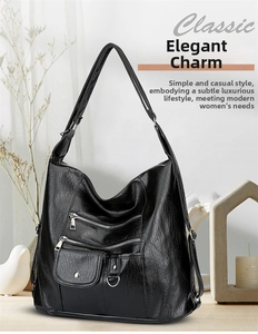 Detail of black faux leather crossbody bag featuring multiple metal zipper pockets and wide strap