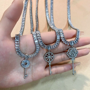 Elegant silver cross key pendant necklace with clear zircons held in hand for display