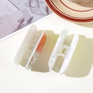 Close-up of marble textured acetate hair clips with transparent spring mechanism