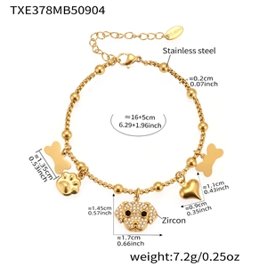 Détail d'un bracelet en acier plaqué or 18 carats avec breloques chien et os en zircon