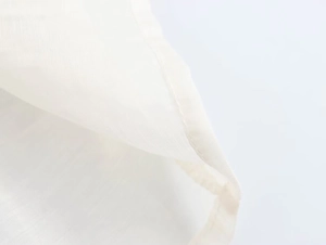 Macro shot of fine stitching and fabric texture on white lace-up romantic blouse