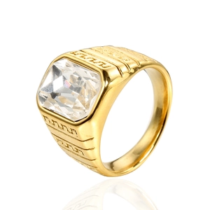 Macro shot of men's gold ring featuring a square clear gemstone and geometric patterns