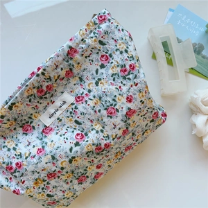 Detail of floral cotton makeup bag featuring 'simple wish' label and delicate rose prints