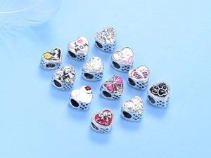 Macro shot of S925 sterling silver heart charms with Mother's Day engravings and bow designs