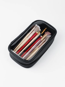 Dettaglio della trousse nera impermeabile con finestra trasparente e pennelli professionali