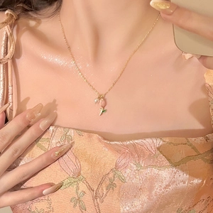 Elegant gold tulip pearl necklace on a female model wearing a floral summer dress