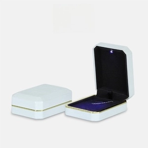 White jewelry box with LED light and black velvet interior for emerald rings