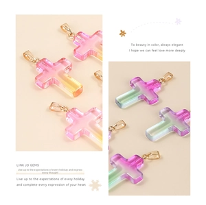 Macro shot of colorful gradient glass cross pendants with elegant golden metal clasps