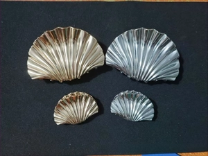 Detail of gold and silver shell hair claws in large and small sizes with ribbed texture