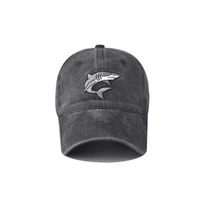 Close-up of a washed cotton baseball cap with detailed shark embroidery on dark gray fabric