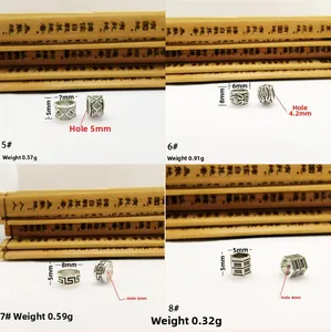 Detailed view of four antique silver alloy spacer beads with ethnic patterns and dimensions