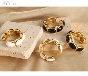 Detail of vintage gold U-shaped earrings with black and white enamel on stone surfaces