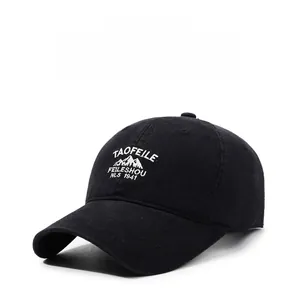 Detail of classic black cotton baseball cap with white embroidered mountain peak graphics