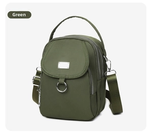 Detail view of olive green nylon crossbody bag with triple zippers and front flap pocket