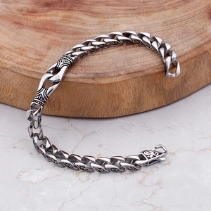 Dettaglio del bracciale vintage in acciaio inossidabile con incisioni nere su legno