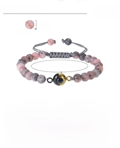 Detail view of 8mm pink zebra stone projection bracelet with adjustable hand-woven cord