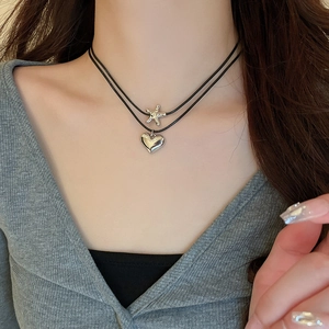 Double-layer cord necklace with silver star and heart pendants on a black leather strap
