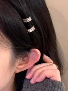 Détail de mini pinces à cheveux en zircon étincelant portées sur le côté en duo