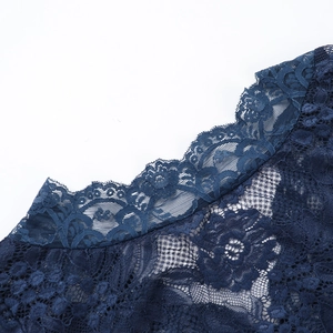 Close-up detail of dark blue intricate lace fabric with elegant hollow out embroidery