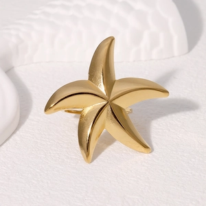 Polished gold starfish ring in stainless steel for beach vacations on white background