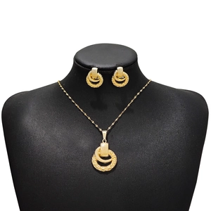 Detail view of a gold-toned double-circle interlocking jewelry set on a black bust model