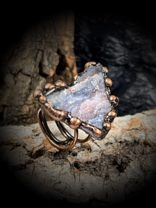 Gros plan de bague artisanale en bronze avec pierre naturelle d'agate solaire brute