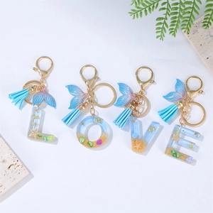 Detailed shot of ocean-style keychains with LOVE letters, whale tails and blue tassels