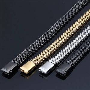 Detail of four stainless steel braided hip hop bracelets in black, gold, silver and grey