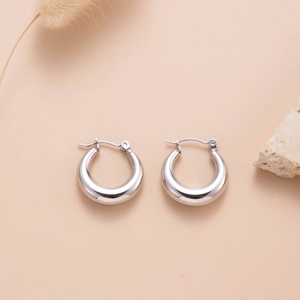 Minimalist silver thick hoop earrings in polished stainless steel on a natural background