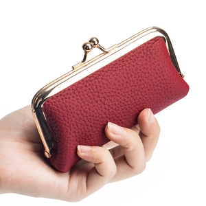 Mini red genuine leather coin purse with golden frame clasp held in hand for size display