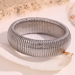 Macro shot of silver striped elastic snake chain metal bracelet with textured finish