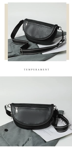 Detail of black crescent crossbody bag with lychee texture and striped canvas strap