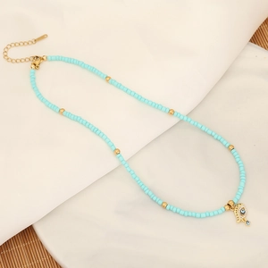 Detailed view of bohemian turquoise beaded necklace with golden Hamsa evil eye pendant