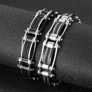 Rugged men's steel cable bracelets in black and silver finishes on dark background