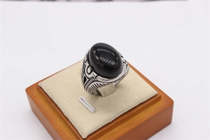 Gros plan sur bague cabochon noir ovale avec détails gravés de style rétro