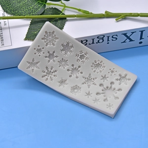 Multi-cavity snowflake silicone mold for DIY baking and cake decorating on a blue background