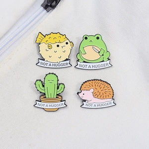 Cute enamel pins featuring pufferfish frog cactus and hedgehog with Not A Hugger text