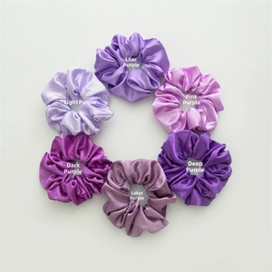 Detailed view of six-piece satin scrunchies set in various shades of purple silk fabric