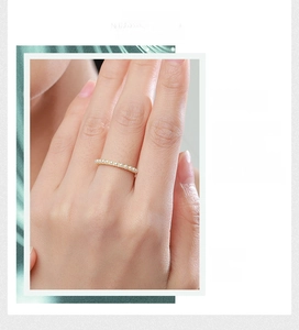 Detailed close-up of a slender gold-plated 925 silver ring with small white pearls