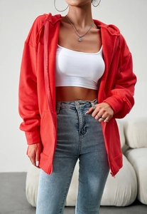 Detailed close-up of a red zip-up hoodie featuring a casual hood and metallic zipper