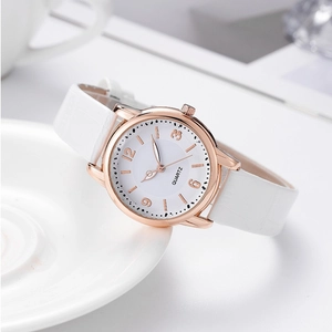 Detail of luxury women's quartz watch with white leather strap and rose gold crystal case