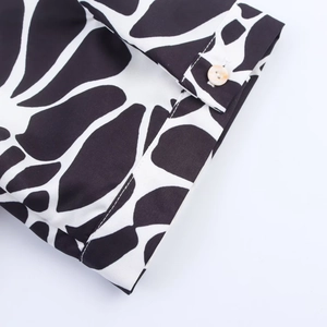 Detail of printed poplin dress cuff with button and black white abstract texture