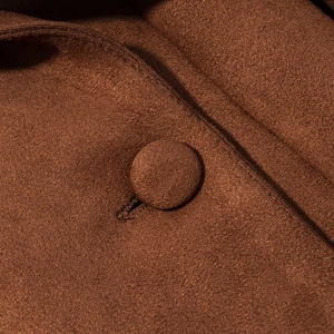 Detailed close-up of brown suede jacket with color-matched fabric buttons and stitching